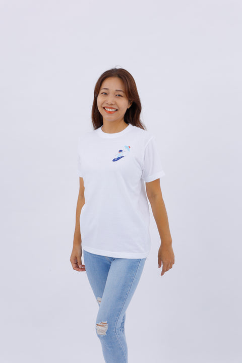 Front view of a woman wearing the "Surfing" white T-shirt, smiling and standing against a white background.