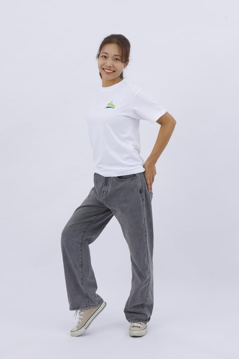 Full-body front view of the model in the "Train" T-shirt and gray pants, striking a casual pose.