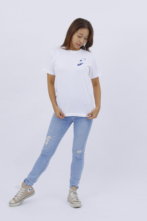 Full-body front view of the model in the "Surfing" T-shirt and light blue jeans, standing casually.