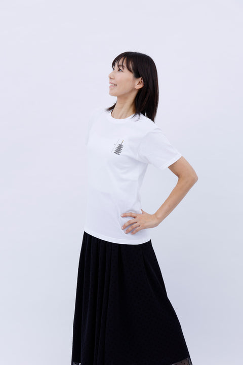 Angled side view of the woman wearing the "Five-story Pagoda & Kaiju Monster" T-shirt and skirt, posing with one hand on her hip.