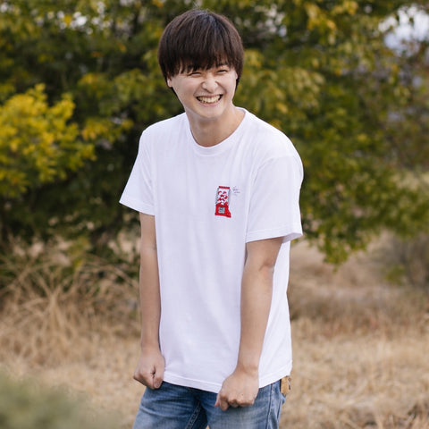 Smiling man wearing a Gacha Gacha graphic T-shirt outdoors
