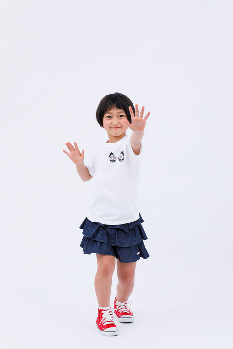 Full-body front view of the child wearing the "Sumo Wrestler & Ayatori" T-shirt and skirt, raising both arms.