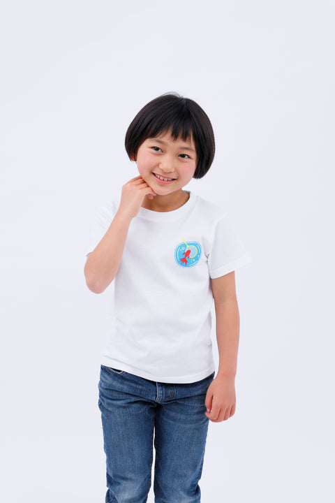 Front view of a smiling child wearing the white "Kingyo Sukui" T-shirt and blue jeans, with one hand touching their chin.