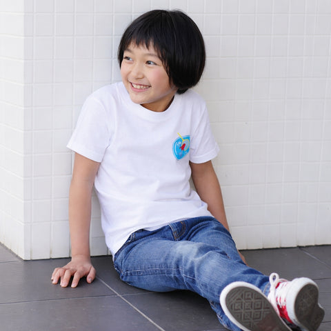 Smiling child wearing a Kingyo Sukui graphic T-shirt