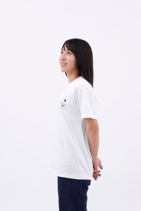 Side view of the woman in the "Summer Holidays" T-shirt and jeans, with hands clasped behind her back.