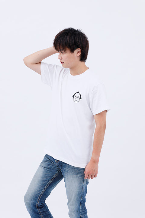 Side view of the man in the "Edo Face" T-shirt and jeans, resting one hand on his head.