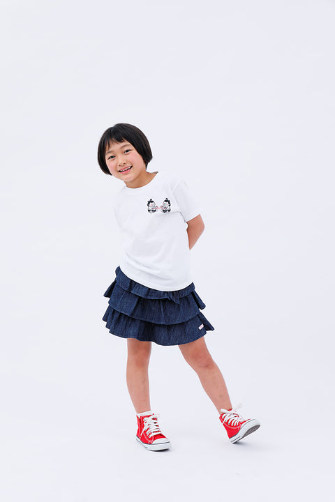 Full-body front view of the child in the "Sumo Wrestler & Ayatori" T-shirt and skirt, posing playfully.