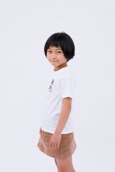 Side view of the child in the "Sparrow in Love" T-shirt and skirt, smiling gently.