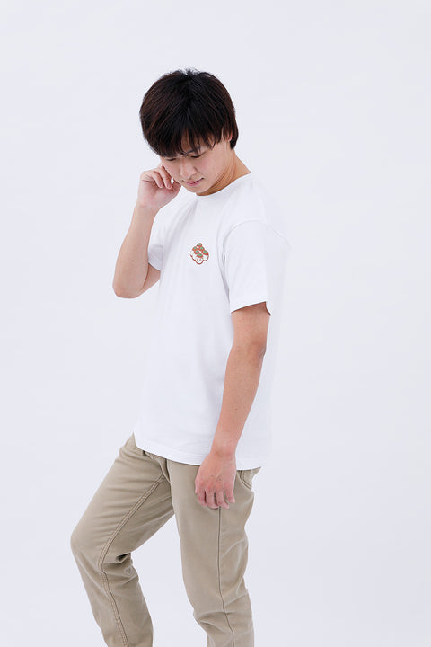 Side view of the man in the "Takoyaki" T-shirt and beige pants, touching his chin thoughtfully.