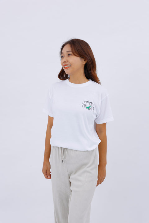 Front view of a smiling woman wearing the white "Mochi-tsuki" T-shirt and light beige pants.