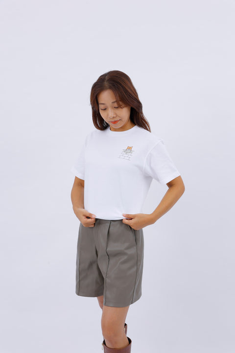 Angled side view of the model wearing the "Shiba Inu" T-shirt, posing with one hand on her hip.