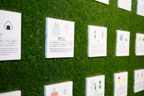 Shop wall with square cards showing illustrations and descriptions of ONE POINT T-shirt designs.